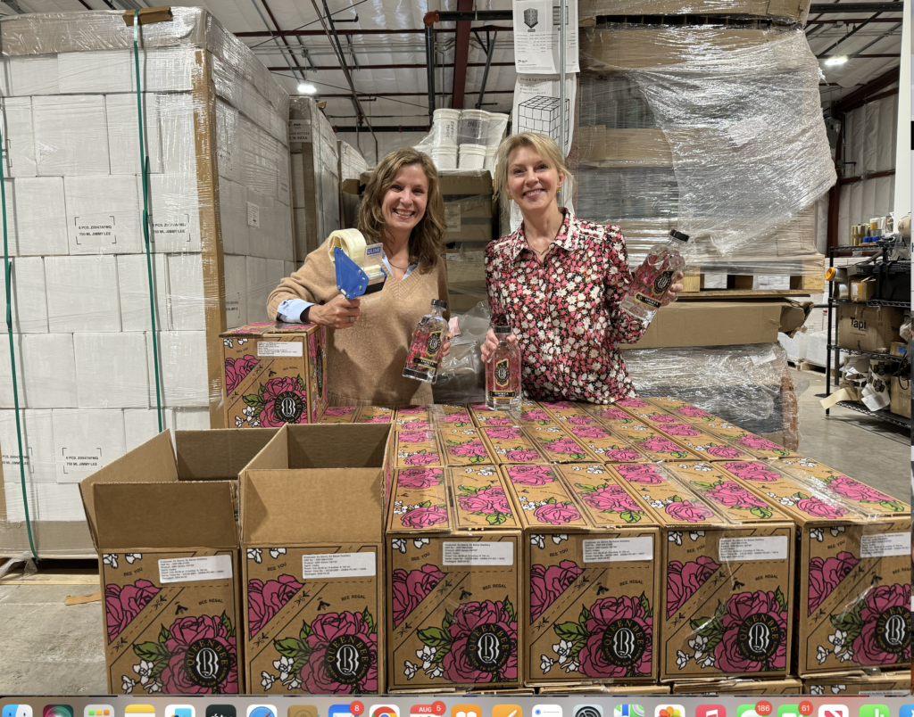 Kim Martin and Catherine Faulconer at work labeling and shrink wrapping boxes of their Queen Bee Osmia vodka. 